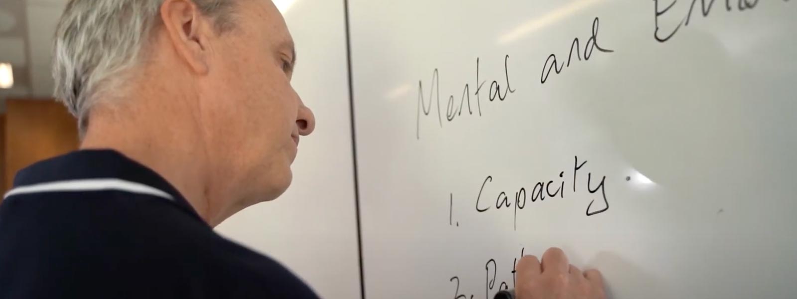 A Lifeline Training educator writes on a whiteboard.