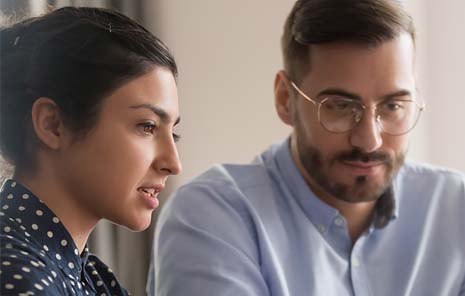 A woman and a man in office shirts having a conversation.