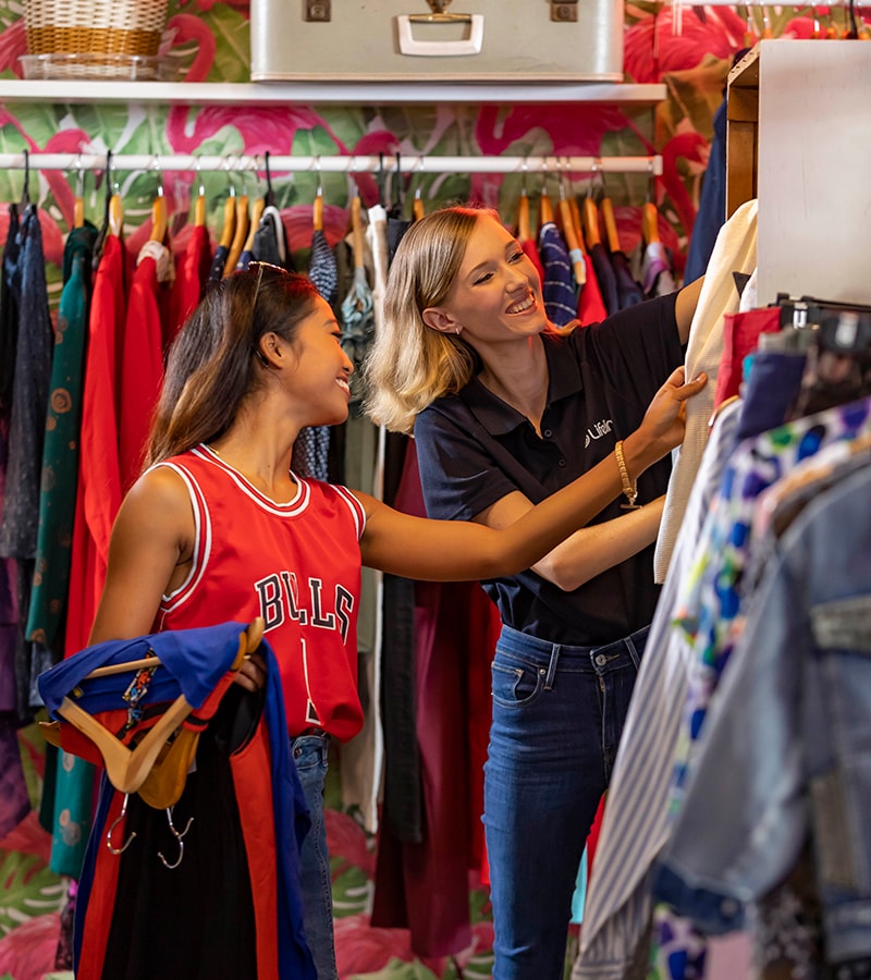 Lifeline Shop Volunteer with customer A female Lifeline volunteer helps a female customer choose clothes in a Lifeline shop